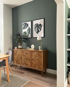 a dining room with green walls and wooden furniture