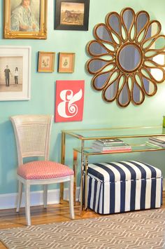 a living room with pictures on the wall and a chair in front of a table