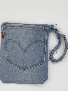 the back pocket of a pair of jeans with frayed edges and an open zipper