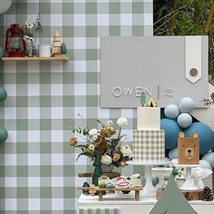 there are many items on the table in this room that is decorated with green and white checkered wallpaper