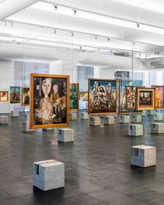 an art gallery with paintings and sculptures on the floor in front of glass partitions