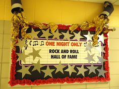 a sign that says rock and roll hall of fame hanging from the ceiling in front of a tiled wall