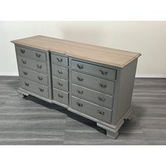 a large gray dresser sitting on top of a wooden floor