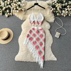 two piece swimsuit with straw hat and flowers on the ground next to white flowers