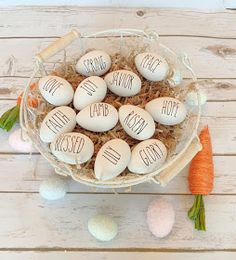 a bowl filled with eggs sitting on top of a table next to carrots and flowers