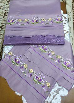 three pieces of purple cloth with flowers on them