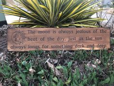 a wooden sign that says the moon is always jeous of the heat of the day, just as the sun always longs for something dark and deep