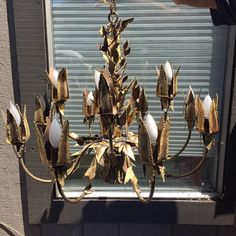 a gold chandelier hanging from the side of a window