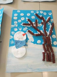 a paper plate with a snowman made out of sticks