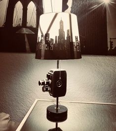 a lamp that is sitting on top of a table with a camera in front of it