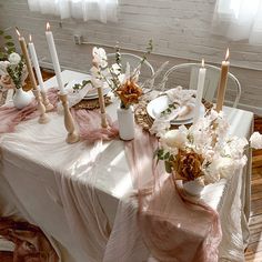 the table is set with flowers and candles