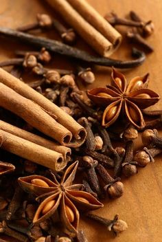 cinnamons, star anise, and cloves on a wooden cutting board