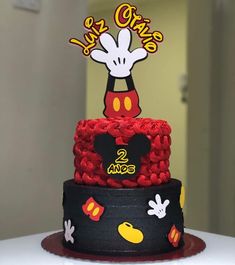 a mickey mouse birthday cake with red and black icing on it's top