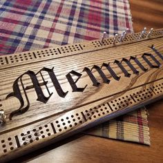 a wooden sign sitting on top of a table next to a checkered table cloth