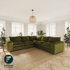 a large green couch sitting on top of a wooden floor next to two potted plants