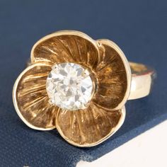 We've grown quite fond of this retro gold floral ring, set with a sparkly and prismatic antique Old European cut diamond in the center! This sweet-as-pie ring has so much charm, from the engraved details of the inner petals to the patina developed throughout. Not to mention that fiery old cut diamond center! 14kt yellow gold Size 6.5 & resizable Diamond is estimated to be N/O color & VS2/SI2 clarity. GIA Standards Please see qualitative report for more information. Video Below Modern Mens Rings, Art Jewelry Earrings, Jewel Necklace, Floral Ring, Antique Watches, Antique Engagement, European Cut Diamonds, Vintage Band, Shop Engagement Rings