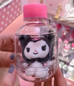 a person holding a small stuffed animal in a glass jar