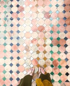 a person standing on a tiled floor with their feet in the air and one foot up