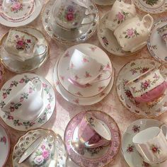 a table topped with lots of plates and cups covered in pink floral print on them