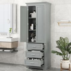 a bathroom with a sink, mirror and grey cabinet in the corner next to a potted plant