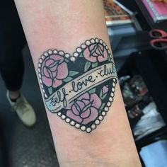 a heart shaped tattoo with roses and words on the arm that says self love club