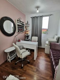 a room with a chair, desk and mirror in it that is painted pink on the walls