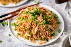 a white plate topped with fried rice and veggies next to chopsticks