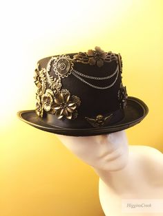 "Neo-Victorian top hat combining a vintage Victorian style with subtle eccentricity of mechanical aesthetic of steampunk, this unisex top hat is fitted with a variety of Victorian vintage baubles and fantastical cogs & gear ornaments on a formed Felt hat with with Ribbon Band. Choosing the custom theme Hat option? Whether you are a high-society aristocrat, a brilliant Steam engineer or a greasy Steam-machine mechanic, your customized hat will work wonderfully with almost any ensemble. S I Z Steampunk High Crown Hat Band For Festivals, Steampunk Festival Hat Band, Gothic High Crown Costume Hat, Steampunk Fitted Brimmed Top Hat, Punk High Crown Top Hat For Festivals, Vintage Halloween Costume Hats And Headpieces, Punk Mini Hat With High Crown For Costume Party, Steampunk Adjustable Hat Bands With Flat Crown, Vintage Mini Hats For Halloween Festival