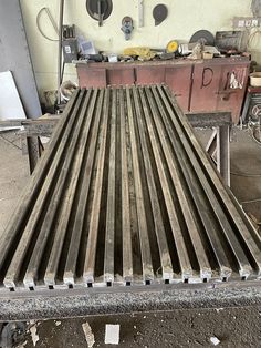 a large metal object sitting on top of a wooden table in a room filled with tools