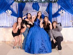 a group of women pose for a photo in front of a blue backdrop with lights