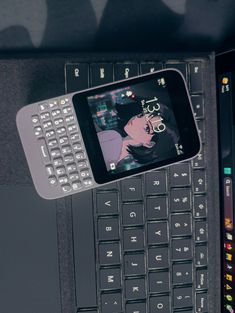 a cell phone sitting on top of a laptop computer