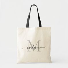 a tote bag with the letter m in cursive writing, on it