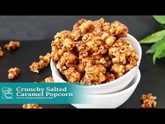 crunchy salted caramel popcorn in a white bowl on a black surface with green leaves