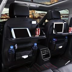 the back seats of a car with electronic gadgets and drinks in them on display