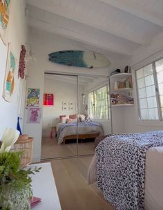 a bedroom with a surfboard hanging from the ceiling and a bed in the corner