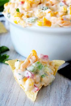 a white bowl filled with corn salad and chips