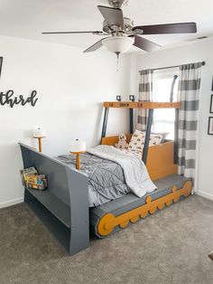 a child's bedroom with a bunk bed and gray carpeted flooring, white walls and ceiling fan