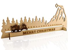 a wooden christmas card with a sleigh and trees