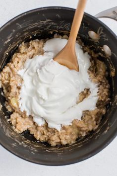 a bowl filled with oatmeal and cream on top of a white table