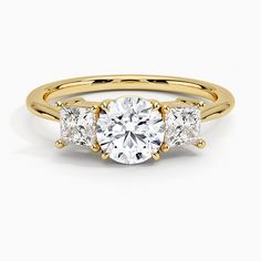 three stone engagement ring in yellow gold with diamonds on the sides and an accent band