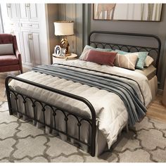 a bedroom with a bed, chair and pictures on the wall above it that is decorated in grey tones