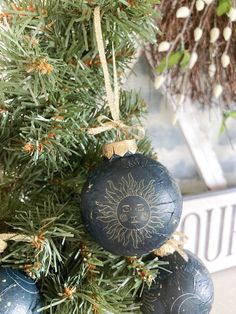 an ornament hanging from a christmas tree with sun and moon designs on it