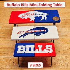 three buffalo bills folding tables on top of a wooden table with the words buffalo bills in red, white and blue