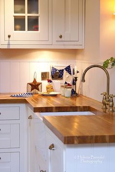 a kitchen with wooden counter tops and white cabinets