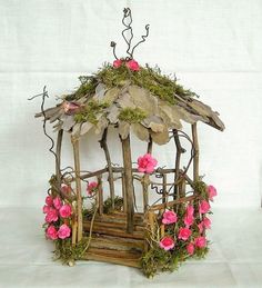 a small wooden gazebo with pink flowers on it