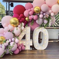 the number ten is decorated with balloons and flowers