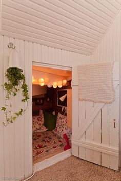 an open door leading into a bedroom with white walls and wood paneling on the ceiling