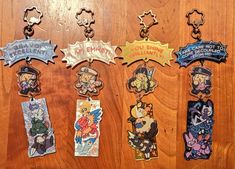 six different key chains with cartoon characters on them sitting on a wooden table next to each other