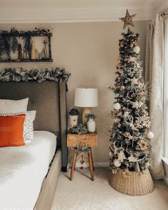 a bedroom decorated for christmas with a small tree in the corner and decorations on the bed