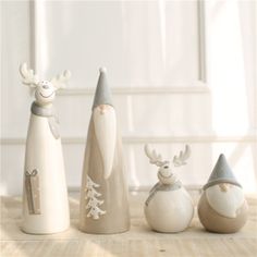 three ceramic figurines in the shape of santa and reindeer